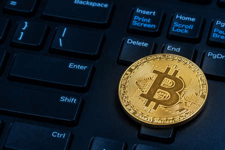 Bitcoin on compuer keyboard in background, symbol of electronic virtual money and mining cryptocurrency concept.の写真素材