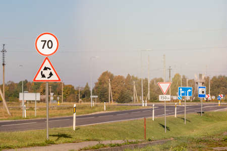 Highway with speed limit 70 road sign, roundabout aheadの写真素材