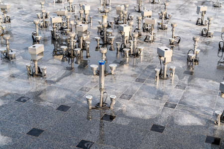 Modern fountain pipes with led lights in an drained empty poolの写真素材