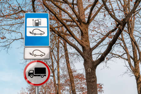 Electric car charging station road sign with trees backgroundの写真素材