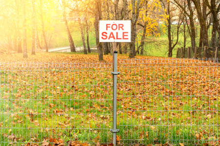 Real estate conceptual image. Land for sale sign  behind the metal fence.の写真素材