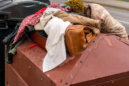 Full container of disposal clothes. Old clothes collection container on the streetの写真素材