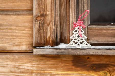Christmas decoration on winter windowsill of wooden house