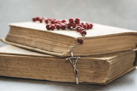Catholic rosary lie on several ancient books. Close-up view.の写真素材
