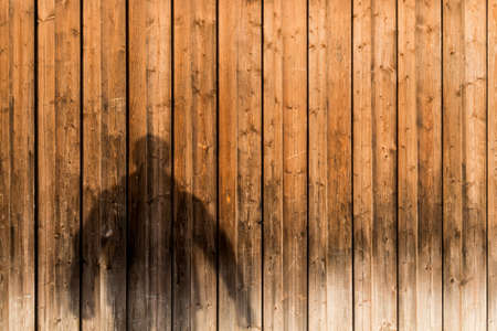 Shadow of a man on wooden background. Copy space.の写真素材