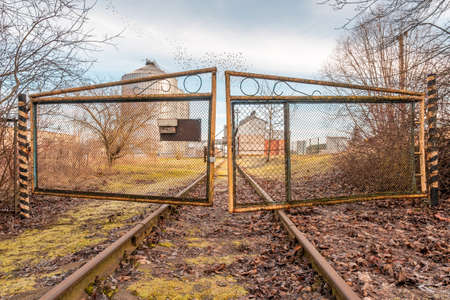 Closed  iron gates and old railway rails for trains. Cargo train checkpoint to agro manufacturing...