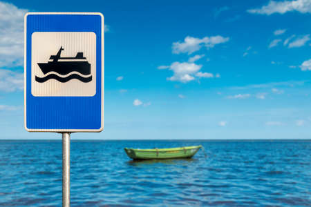 Signpost for boating. Green Rowing Boat anchored at high tide on a flat calm sunny dayの写真素材