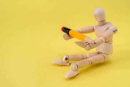Wooden mannequin hold pencil, education concept. Copy-space.