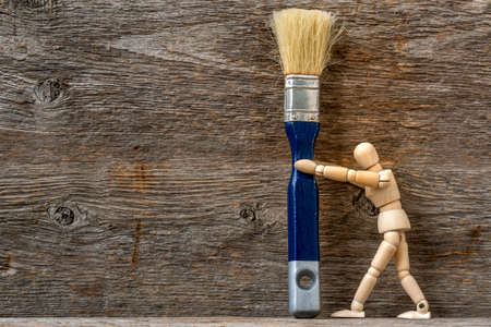 Dummy holding painting brush. The concept of repair, change, design, interior. DIY Home Projects & Repairs To Do While Quarantined at Home.の写真素材