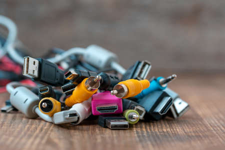 Close up view of different computer cables lying on the wooden tableの写真素材
