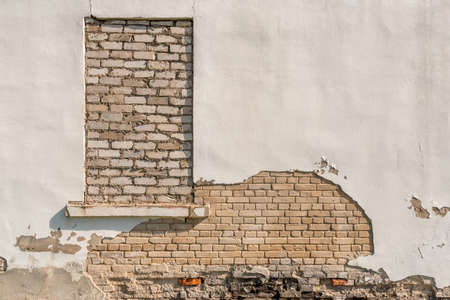 Bricked up window on a old  brick wall with damage surfaceの写真素材
