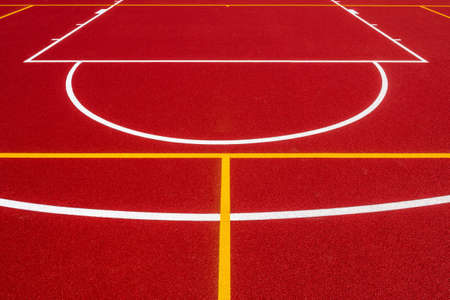 Abstract, red background of newly made outdoor basketball court in park. Visible surface texture, freshly painted linesの写真素材