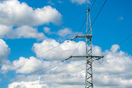 Iron tower with wires electricity transmission on the summer sky background