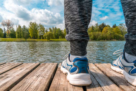 Man standing on the edge of wooden dock with beautiful landscape