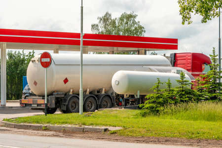 Tanker gas truck delivering fuel at service stationの写真素材