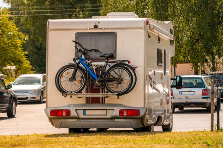 Two pleasure bikes are strapped to the back of the camper van. Rear view. Leisure trip in the summer.の写真素材
