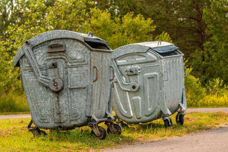 Metal containers for garbage in the green forest, ecology concept