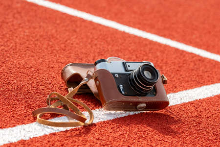 Retro camera on the running track in stadium, sport journalism conceptの写真素材