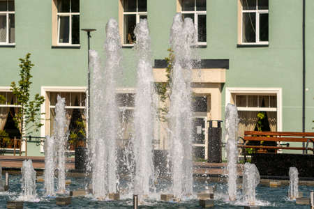 Fountain and water jets on a bright sunny day in a city squareの写真素材