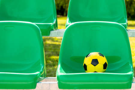 Soccer ball on the green seats of outdoor sports groundの写真素材