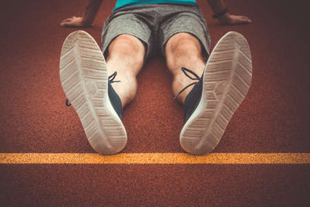 Man runner resting after workout session on the running trackの写真素材