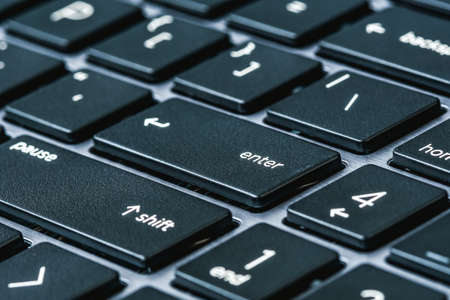 Close up view of computer keyboard with aluminium body. Selective focus. Blue toned image.