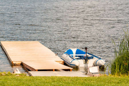 Inflatable motor boat moored to a wooden bridge
