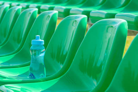 Water bottle on the green seats of outdoor sports groundの写真素材