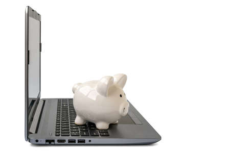 Piggy bank with laptop which means make money online or internet business concepts. Isolated on white background.の写真素材