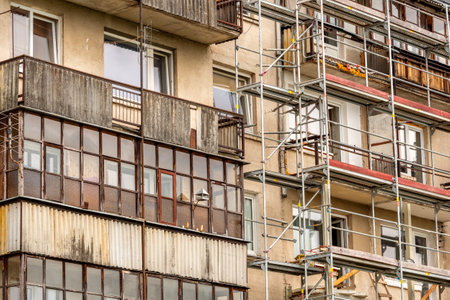 Scaffolding standing against the wall of multistorey building. Renovation of the facade of a multi-storey buildingのeditorial素材