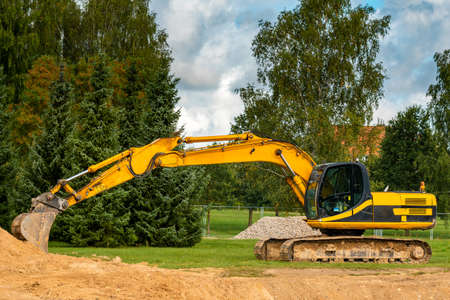 A large construction excavator of yellow color on the construction site in a quarry for quarrying