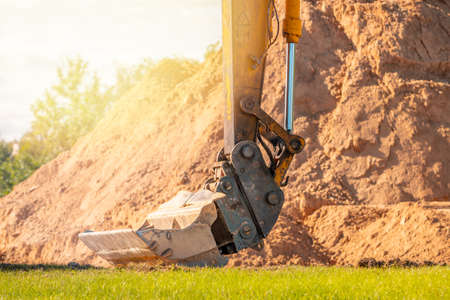 Dirty and rusty hydraulic construction excavator bucket with bucket link at construction site....