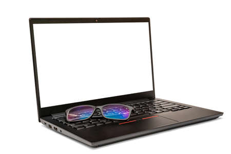 Eyeglasses on the black laptop, isolated on white background. Copy space.