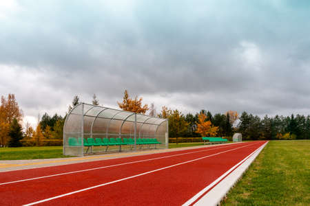 Green chair for spare team near running track in the stadiumの写真素材
