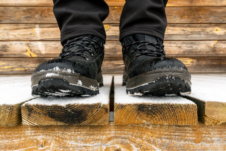 Close-up of a tourist's feet in trekking boots during winter time