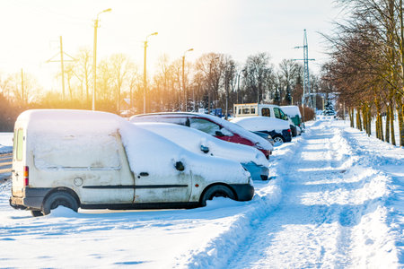 Parking lot with cars sunlit covered in fresh snowの写真素材