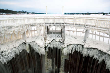 Winter landscape with frozen waterfall on a small damの写真素材