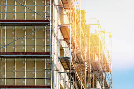 Scaffolding on multi storey building facade during renovation. Bright sunny day.
