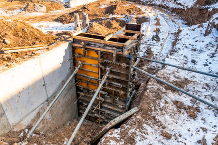 Casting of concrete columns for building house. Construction work in winter season.