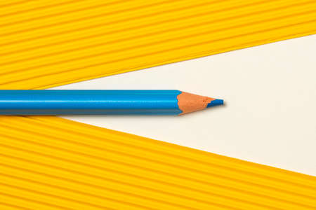 Template with copy space by top view closeup photo of blue pencil put between yellow paperの写真素材