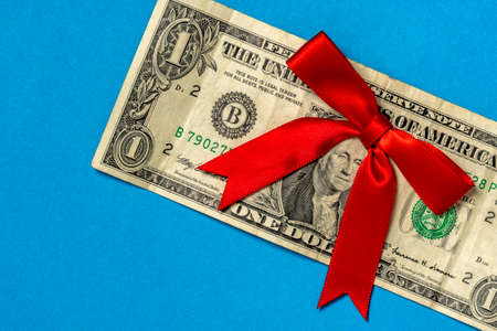 Dollar with decorative bow on blue background in closeupの写真素材