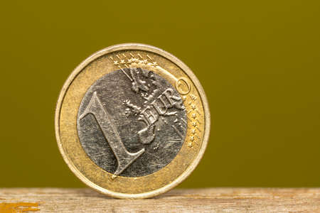 One Euro coin stand alone on the wooden boardの写真素材