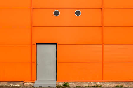 Industrial orange building wall with metal doorsの写真素材