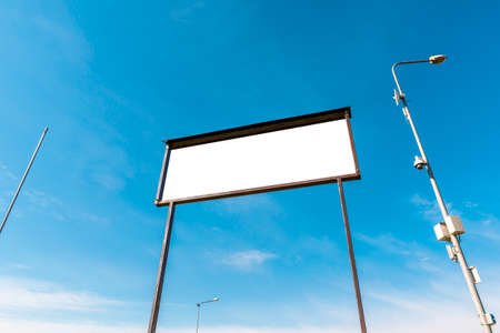 White empty billboard from low angle on sky background