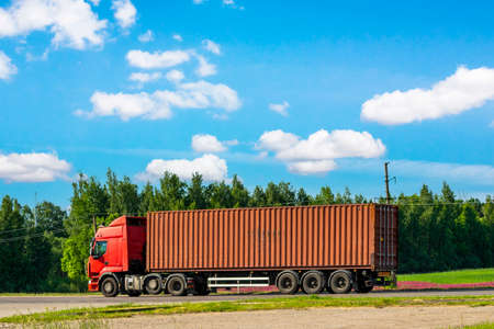Truck on the road with red container. Cargo shipping and transportation concept.