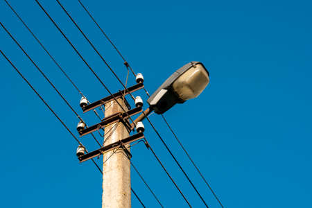 Concrete pillar with a lot of wires and street lampの写真素材
