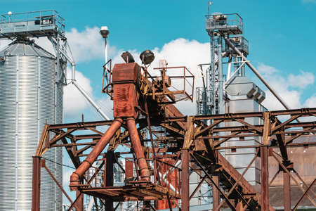 Modern granary elevator. Silver silos on agro-processing and manufacturing plant for processing drying cleaning and storage of agricultural products, flour, cereals and grain.の写真素材