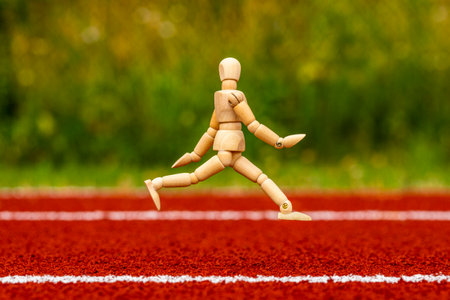 Wooden man  running on the stadium track with rubber surface