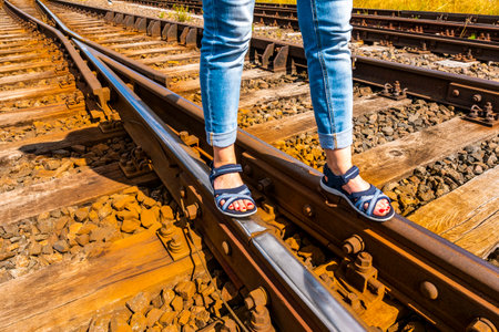 Woman walking on the railroad with summer sandals. Travel concept.の写真素材