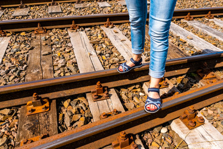 Woman standing on the railroad with summer sandals. Travel concept.の写真素材